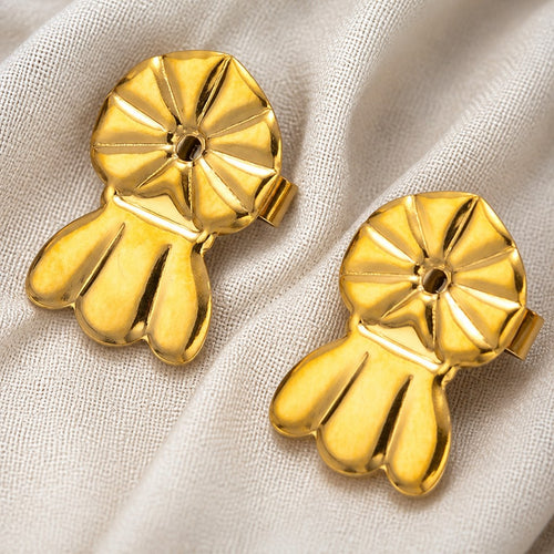 A pair of gold Auralie earring lifters on pale linen